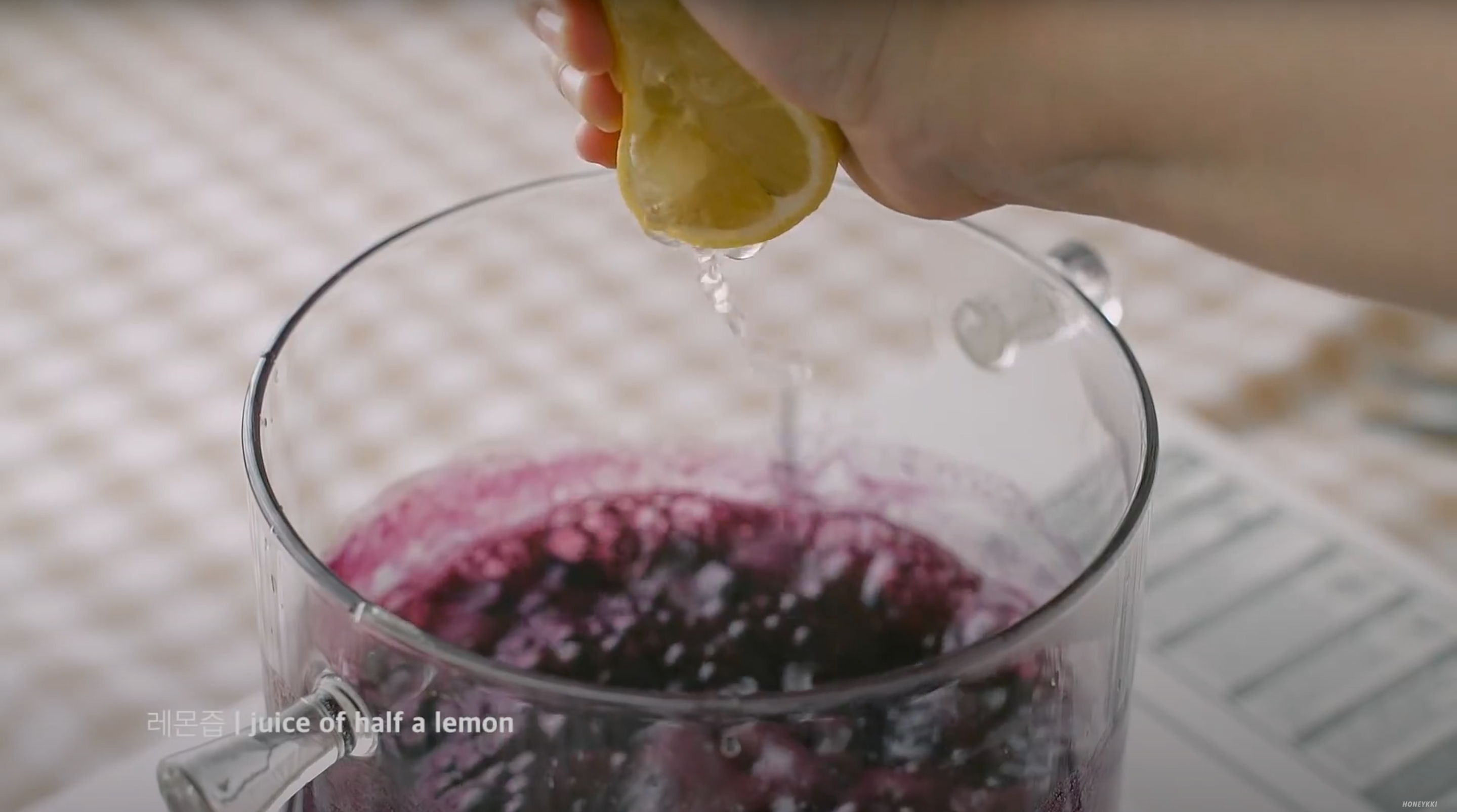 image of squeezing lemon in blueberry and sugar pot